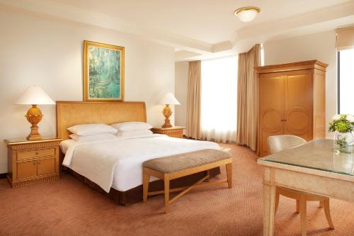 Un pat sau paturi într-o cameră la Aryaduta Suite Semanggi