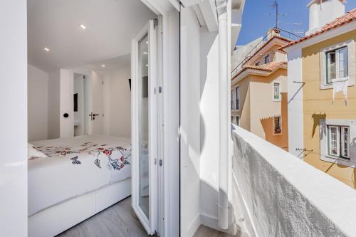 um quarto com uma cama e uma janela aberta em Suprema Lofts III em Lisboa