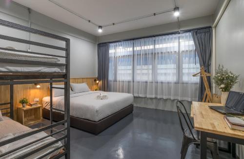 a bedroom with two bunk beds and a desk at Otter House in Krabi town