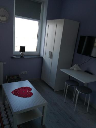 una stanza con tavolo, due sgabelli e finestra di Business Apartments 28 a Bydgoszcz