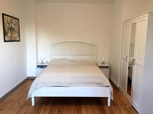 een slaapkamer met een wit bed in een kamer bij Ferienwohnung Elly in Altefähr