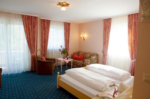 a hotel room with two beds and a table at Hotel KRONE Kressbronn am Bodensee in Kressbronn am Bodensee