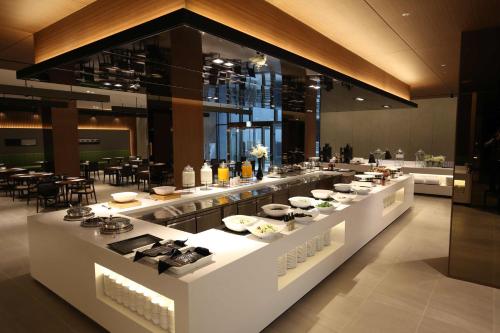 a buffet line in a restaurant with food on display at Ramada Encore by Wyndham Gimpo Han River Hotel in Gimpo