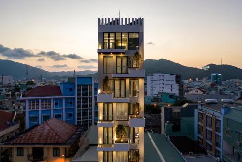 un edificio alto en una ciudad al atardecer en HAKU Boutique Hotel Quy Nhơn - Lê Lợi, en Quy Nhon