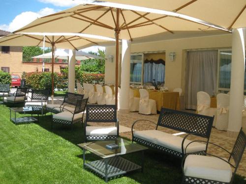 a group of chairs and tables under an umbrella at Hotel Holiday Sul Lago in Bolsena