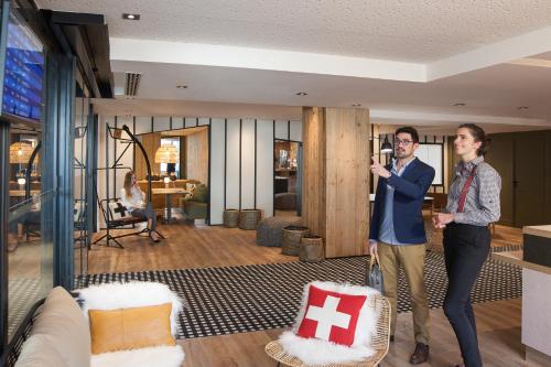 a man and a woman standing in a living room at Mercure Chambéry Centre in Chambéry