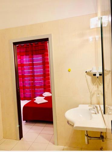a bathroom with a sink and a red window at Residence Domus in Rimini