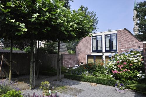 a brick house with a garden in front of it at Appartement Bokhamer in Tilburg