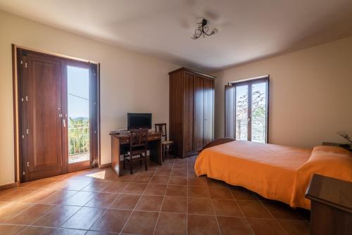 a bedroom with a bed and a desk with a television at Villa Pandora in Agropoli