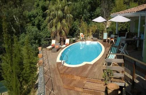 a swimming pool on a wooden deck next to a house at Rayol-Canadel in Rayol-Canadel-sur-Mer