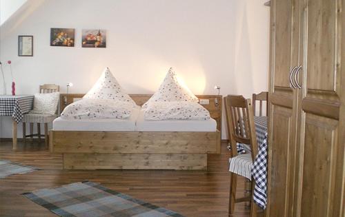 a bedroom with a wooden bed with pillows on it at Pension Barbara in Mainburg