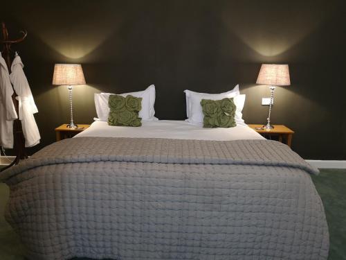 a bedroom with a large bed with two lamps at The Priory in Middleham