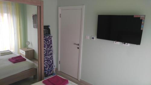 a bedroom with a tv on the wall and a bed at Your Home Montenegro in Dobra Voda