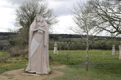 a statue of a woman holding a child in a field at Fontaine Blanche River View, Large Patio & Garden in Central Brittany with Starlink WiFi in Treffrin
