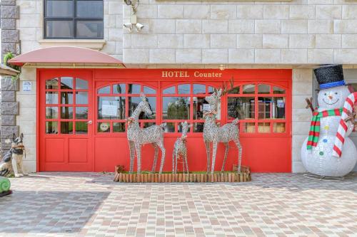 a red building with three giraffe statues in front of it at Milan Yilan in Wujie