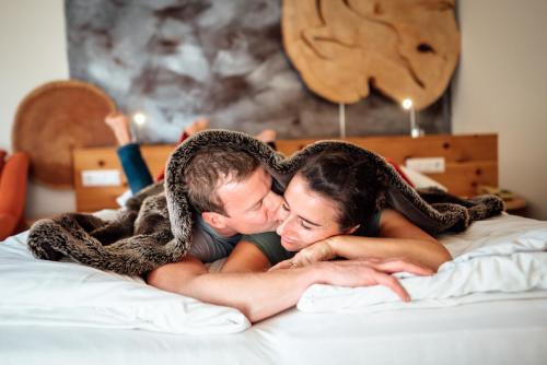 a man and a woman laying on a bed at Der Kirchheimerhof - Superior in Bad Kleinkirchheim