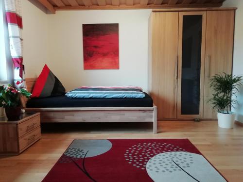 a bedroom with a bed and a red rug at Ferienwohnung Helmberger in Burgkirchen in Burgkirchen an der Alz