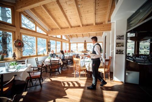 a man standing in a dining room with tables at Der Kirchheimerhof - Superior in Bad Kleinkirchheim