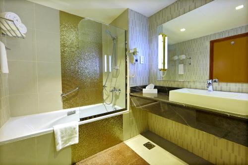 un bagno con vasca, lavandino e doccia di Vision Imperial Hotel Formerly Excelsior Hotel Downtown a Dubai
