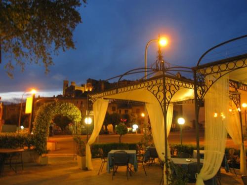 a gazebo with white curtains and tables and chairs at Platani Hotel in Bolsena