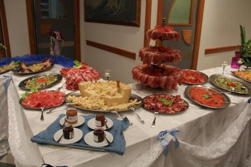 a table with many plates of food on it at Platani Hotel in Bolsena