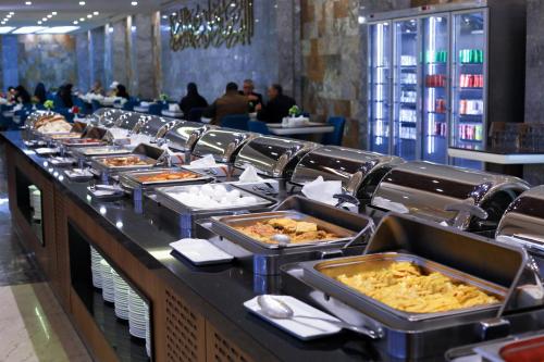 a buffet line with many trays of food at Qasr AlDur Hotel in An Najaf