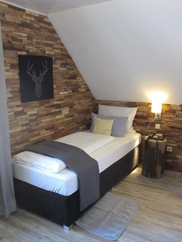 a bedroom with a bed with a brick wall at Hotel Weilerhof in Dormagen