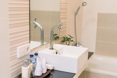 a bathroom with a white sink and a mirror at Taman Bali Villas in Legian