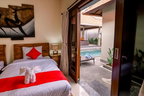 a bedroom with a bed with a stuffed elephant on it at Taman Bali Villas in Legian