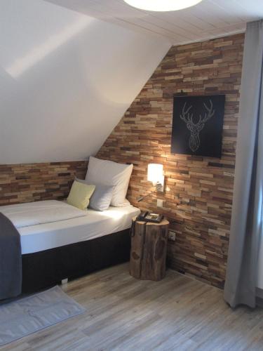 a bed in a room with a brick wall at Hotel Weilerhof in Dormagen