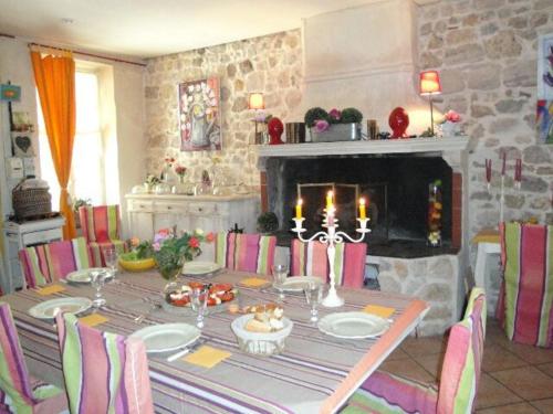 a dining room with a table with chairs and a fireplace at La Maison Bleue de Sigean in Sigean