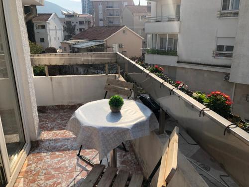 a table on a balcony with a potted plant on it at Villa Merci Budva in Budva
