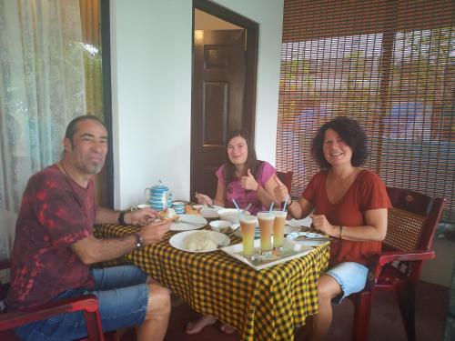 a group of people sitting around a table at Marari Lotus Beach Villa in Mararikulam