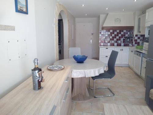 a kitchen with a table and chairs in a room at Appartement en bord de mer in Port-la-Nouvelle