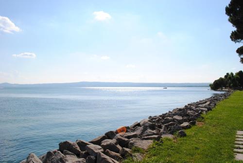 a rock retaining wall next to the water at Hotel Holiday Sul Lago in Bolsena