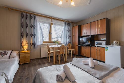 ブコビナ・タトシャンスカにあるAgrotatry U Stachyのベッドルーム1室(ベッド2台、テーブル付)、キッチン