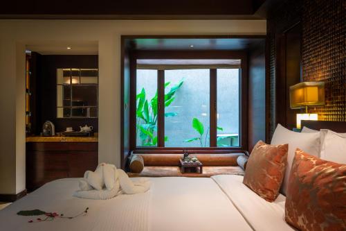 a bedroom with a bed with a window and a sink at Narada Resort & Spa Perfume Bay Sanya - All Villas in Lingshui