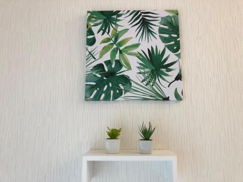 a picture hanging on a wall with two potted plants at Azama Ocean View Terrace in Azama