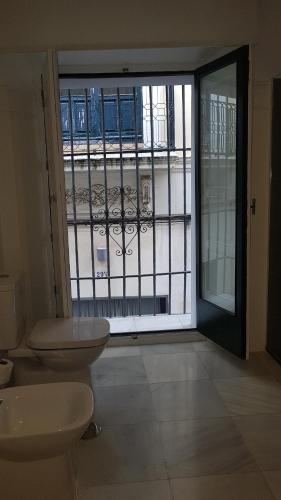 a bathroom with two toilets in front of a window at Basic Hotel Sevilla Catedral in Seville