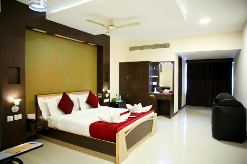 a bedroom with a bed with a red blanket at Hotel Rock Fort View in Tiruchirappalli