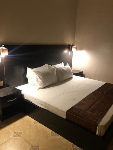 a bedroom with a large bed with white pillows at Posh Apartments Business Hotel in Ikeja