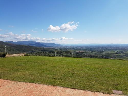 a view of a green field with mountains in the background at Villa Desiderio TUSCANY in Pistoia