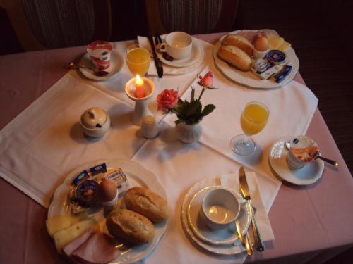 einen Tisch mit Frühstücksplatten und Orangensaft in der Unterkunft Hotel Restaurant Schrotmühle in Scheinfeld