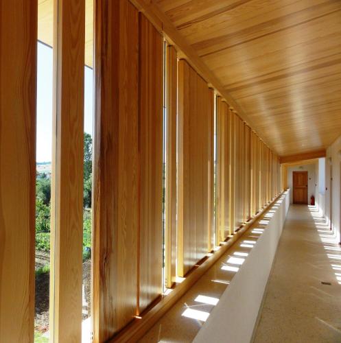 a hallway of a building with wooden walls and windows at Hotel Gracanica in Pristina
