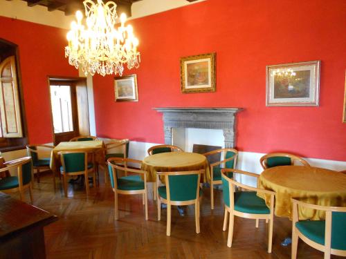 a dining room with tables and chairs and a chandelier at Hotel Bellavista in Abetone