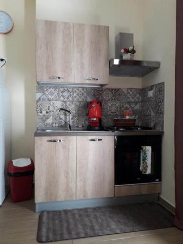 een keuken met houten kasten en een wastafel bij La Casetta del Viale 13 in Palermo