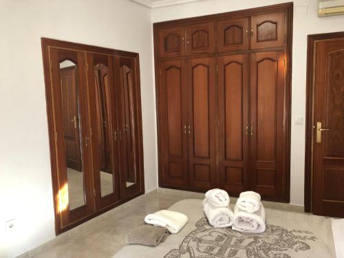 um quarto com toalhas no chão e armários de madeira em Apartamento SC Victoria em Cáceres