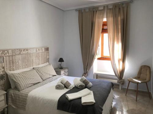1 dormitorio con 1 cama con 2 toallas en Apartamento SC Victoria, en Cáceres