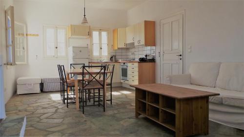 a kitchen and living room with a table and chairs at Vitali Beach Houses in Andros