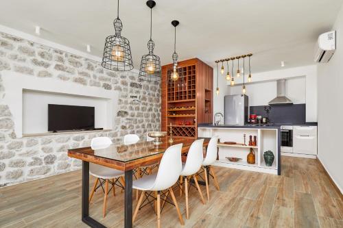 a kitchen and dining room with a table and chairs at Three Dots by Todorovic Family in Kotor